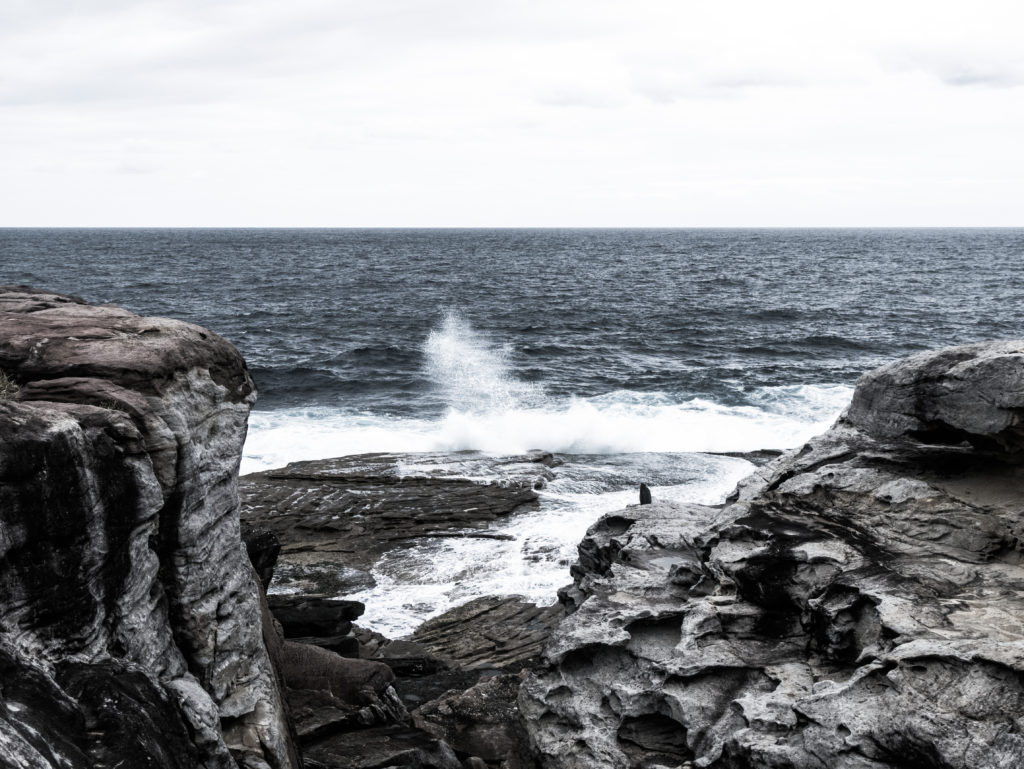 Waves crashing against the cliff near Bondi